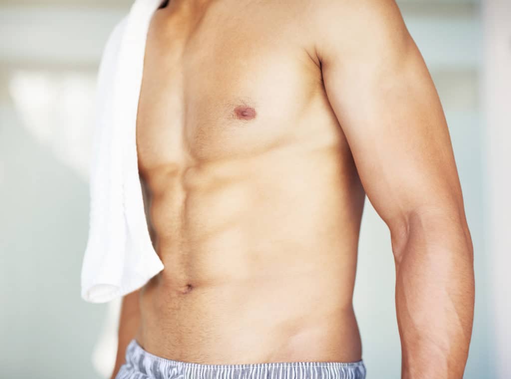 Cropped image of a muscular man with a towel on the shoulder