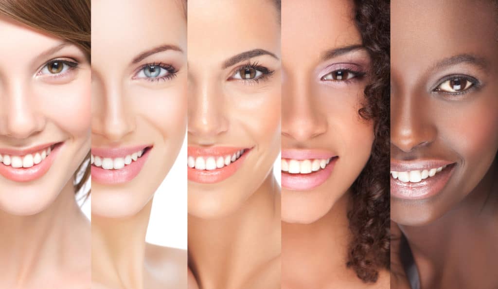 Combination of different smiling women with differenet skin tones.