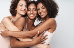 three adorable multiethnic women smiling and hugging together